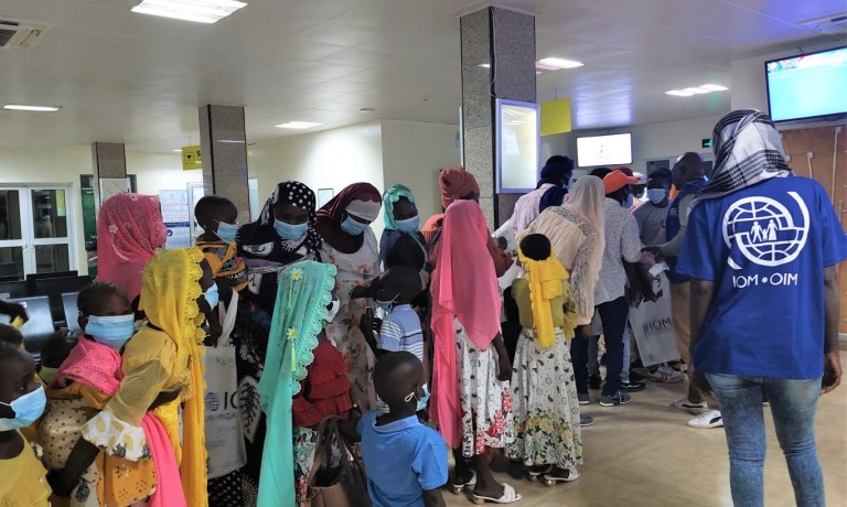 Un groupe de migrants se prépare à embarquer sur un vol charter à N'Djamena. Crédit : OIM/Adeline Tannone 2022